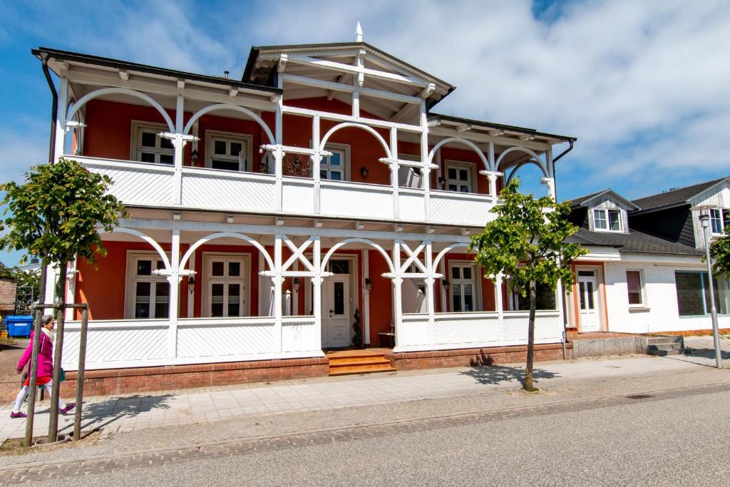 una grande casa rossa e bianca su una strada di Villa Bertha a Ostseebad Sellin
