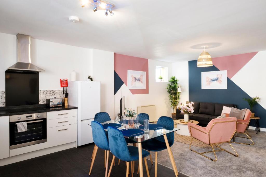 a kitchen and living room with a table and chairs at Corinium Lodge - town centre apartment in Cirencester