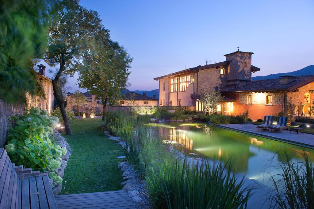 una finca con un estanque frente a un edificio en Boutique Hotel Villa dei Campi, en Gavardo