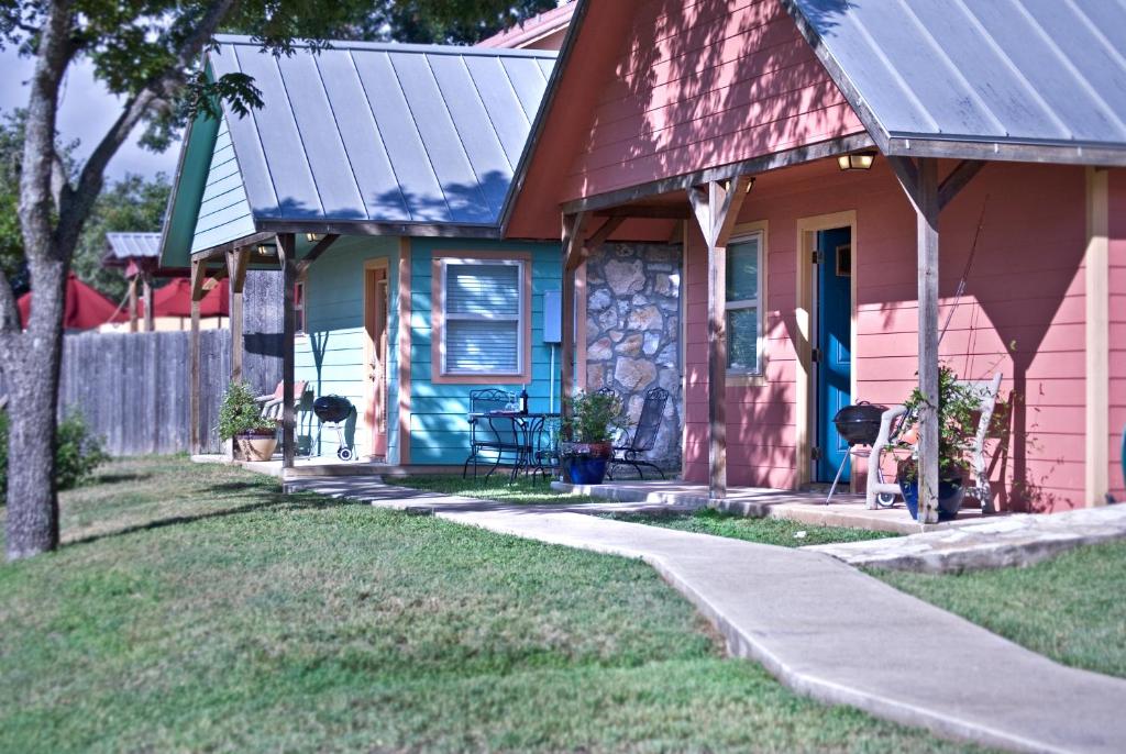 ein farbenfrohes Haus mit rotem Dach und blauer Tür in der Unterkunft Blanco Riverside Cottages in Blanco