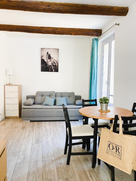 a living room with a couch and a table at OR - studio en plein centre de l'Isle sur Sorgue in L'Isle-sur-la-Sorgue