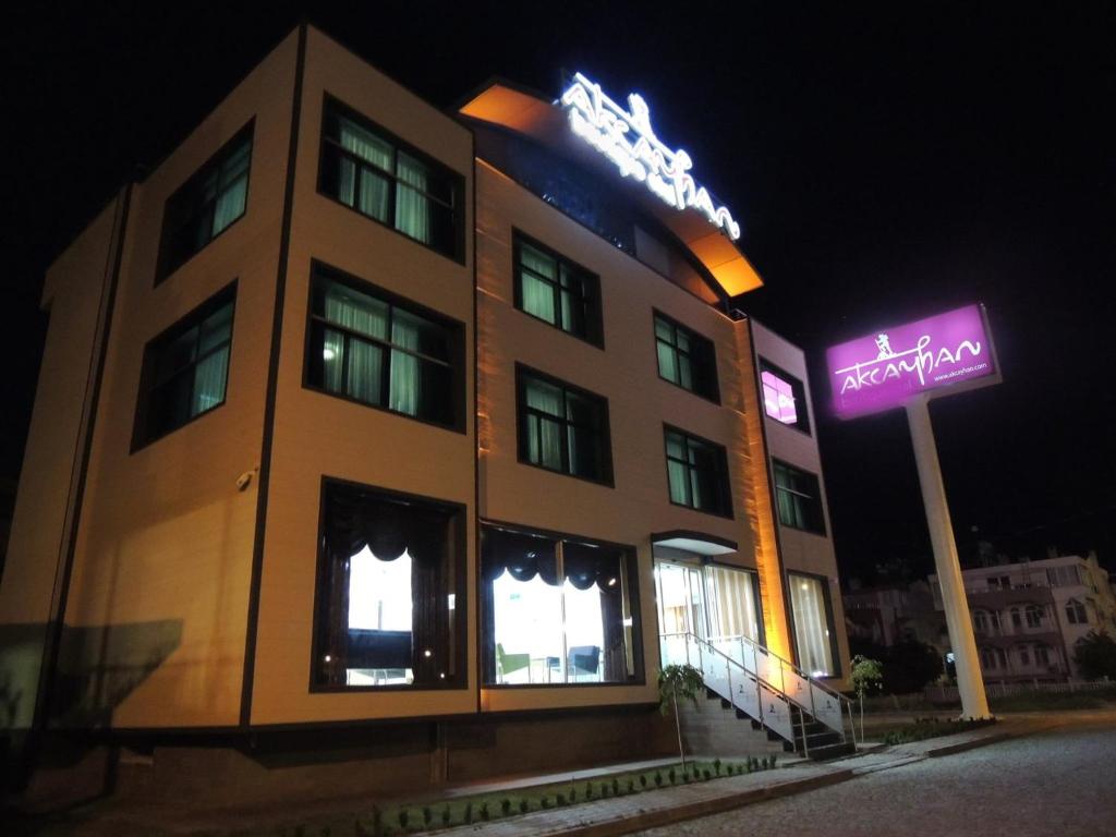 a building with a neon sign in front of it at Akcayhan Hotel in Akçay