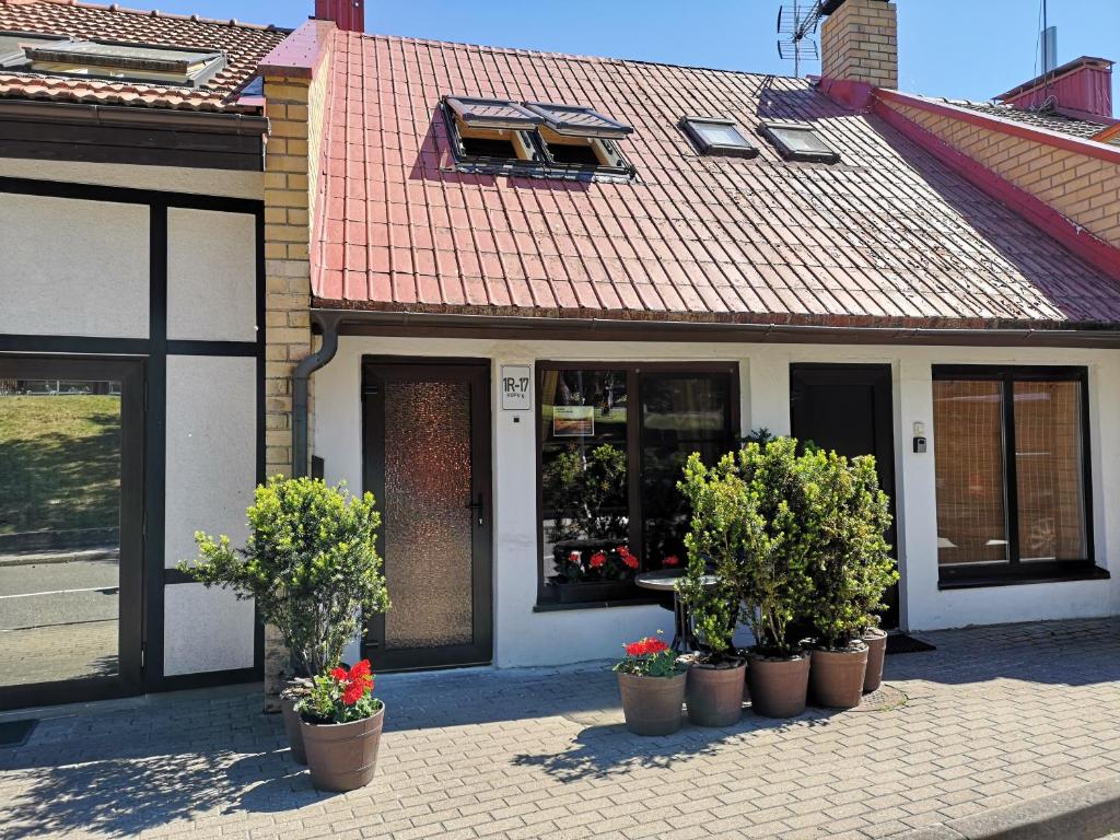 a building with potted plants in front of a store at Mini Kotedžas Vakaris in Nida