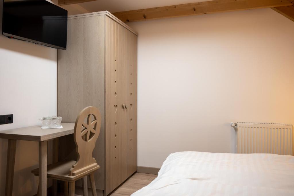 a bedroom with a bed and a table and a desk at Pension Mama Cozonacilor in Bran
