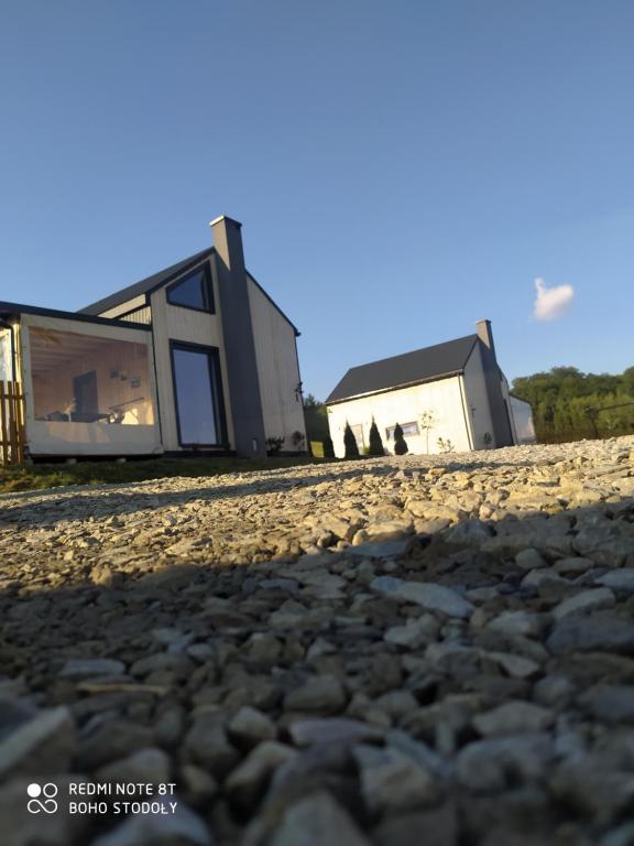 a house on the beach with a rocky ground at Bieszczadzkie BOHO stodoły z jacuzzi i sauna na wyłączność in Myczkowce