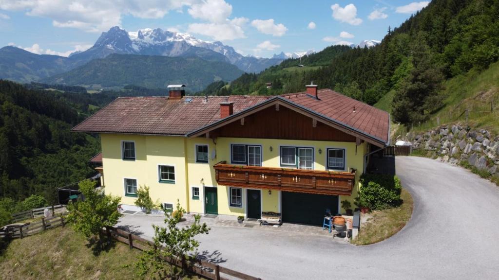una casa en una colina con montañas en el fondo en Haus Alexander en Bischofshofen