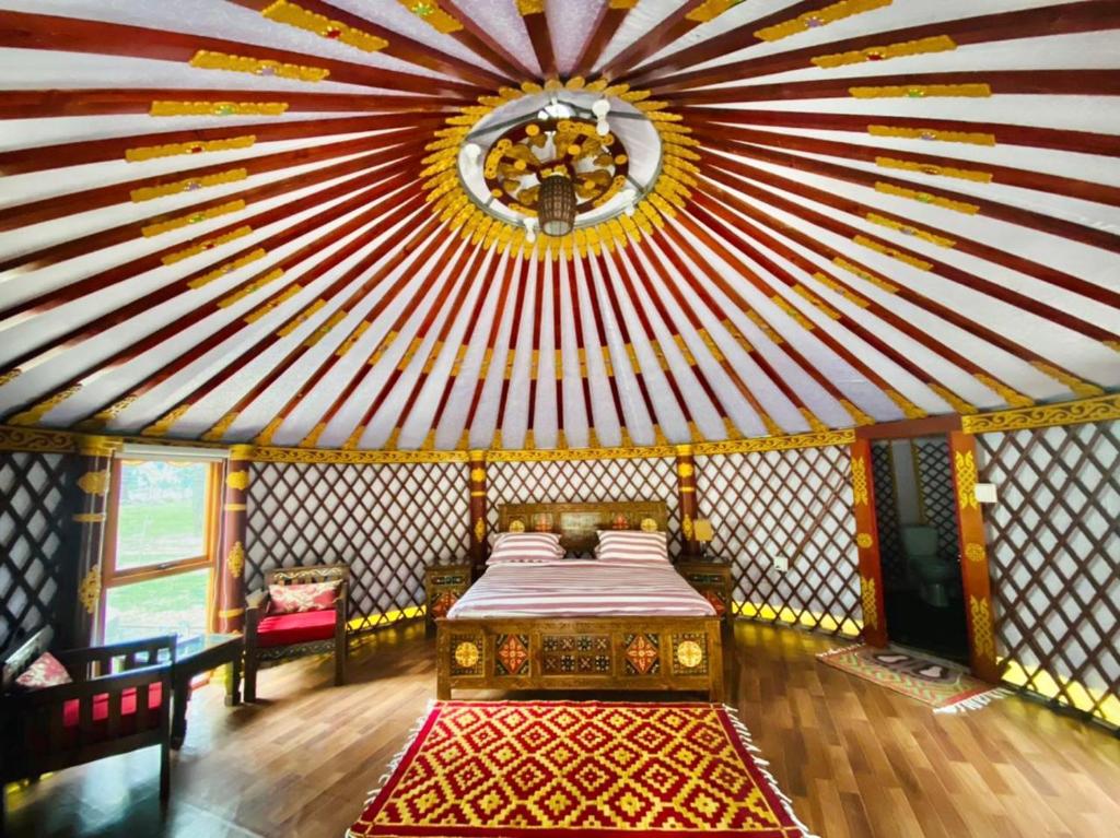 Pokój z łóżkiem i czerwono-białym sufitem w obiekcie The Glamping Spot Kalam w mieście Kalām