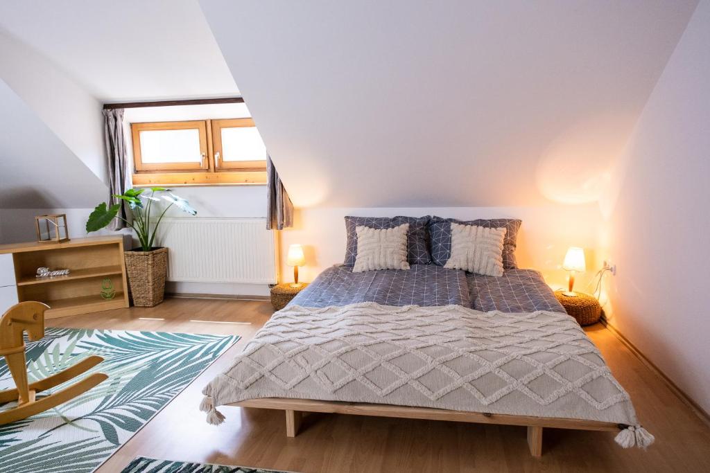 a bedroom with a bed and a window at Sziklai Apartman in Veszprém