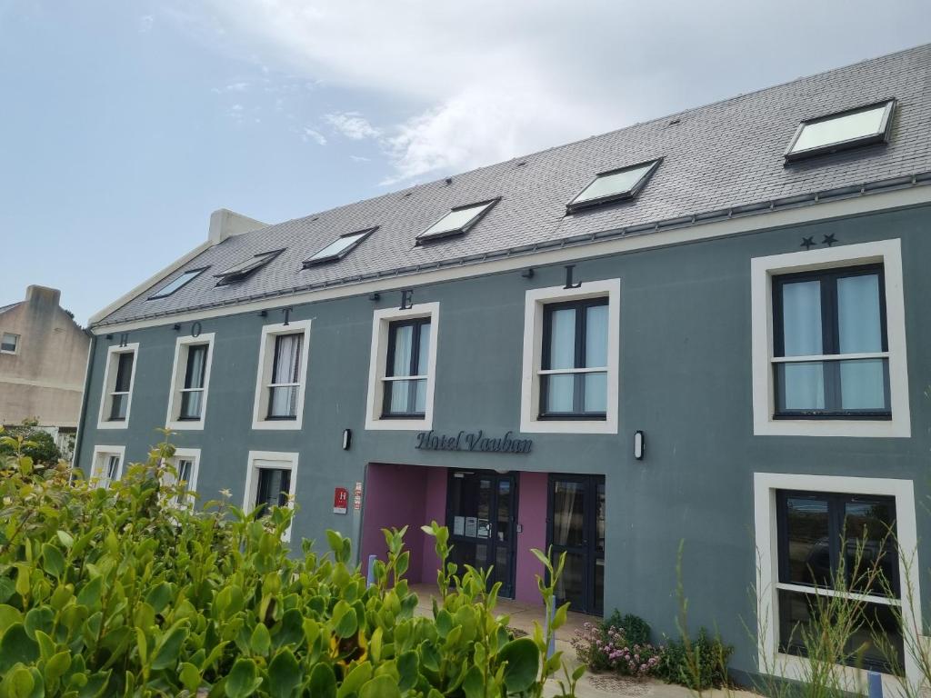 un bâtiment avec des panneaux solaires sur le toit dans l'établissement Hôtel Vauban, au Palais