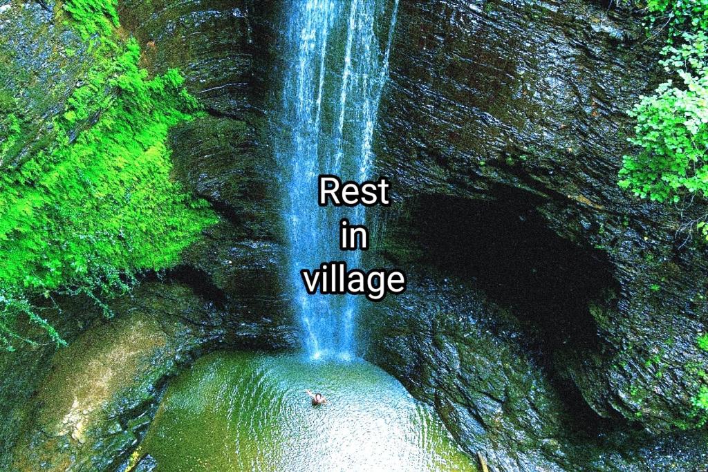 una cascata con le parole che poggiano su di essa nel villaggio di Iveri House a Kutaisi