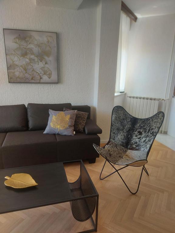 ein Wohnzimmer mit einem Sofa und einem Stuhl in der Unterkunft Apartments Fugosic in Punat