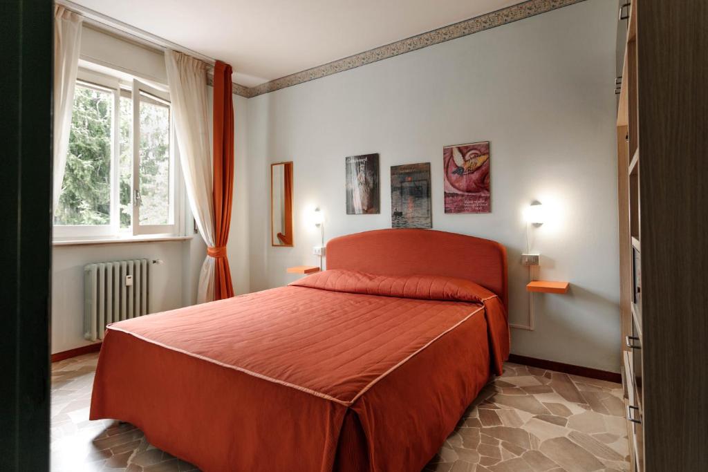 sypialnia z czerwonym łóżkiem w pokoju w obiekcie Locanda Tradate w mieście Tradate