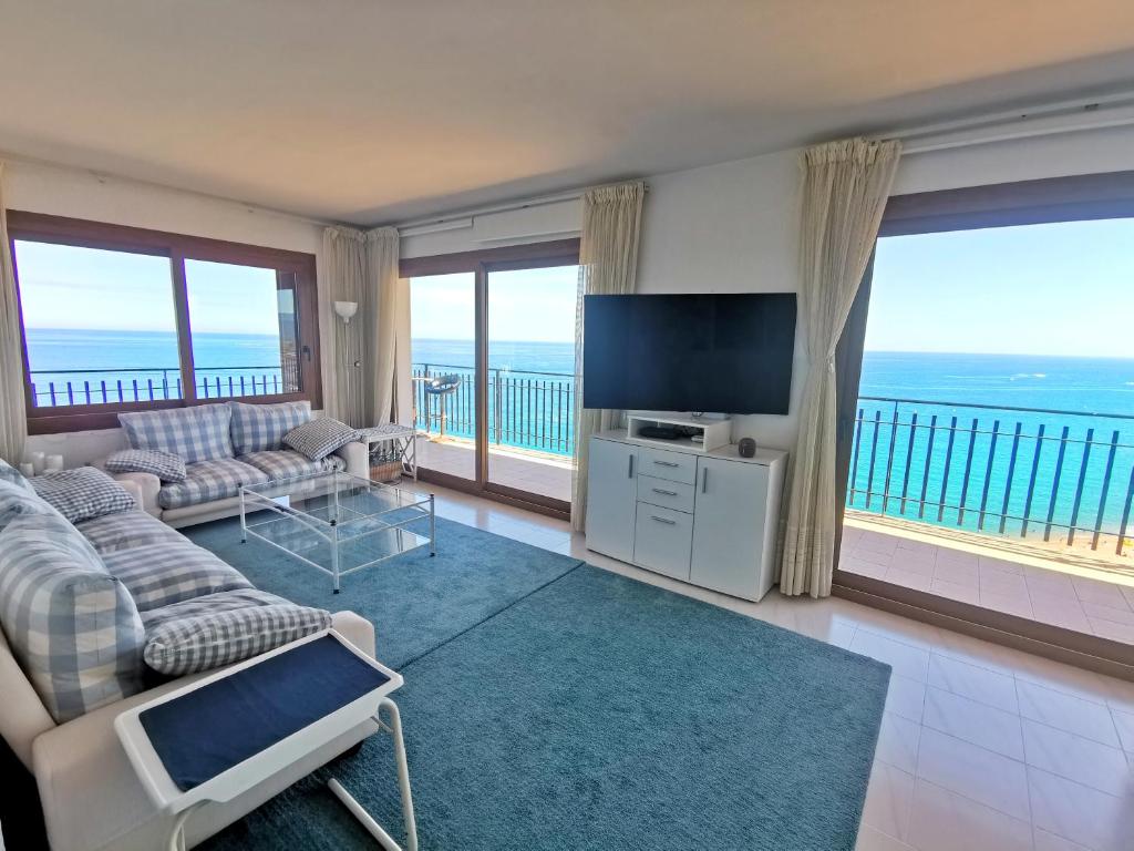a living room with a view of the ocean at Spacious seafront apartment in Platja d'Aro