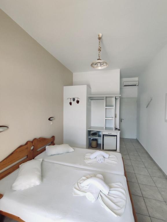 a bedroom with two beds with towels on them at Hotel Aegeon in Mylopotas