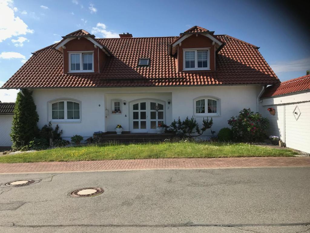 una casa bianca con tetto rosso di Ferienwohnung Helga a Walkenried