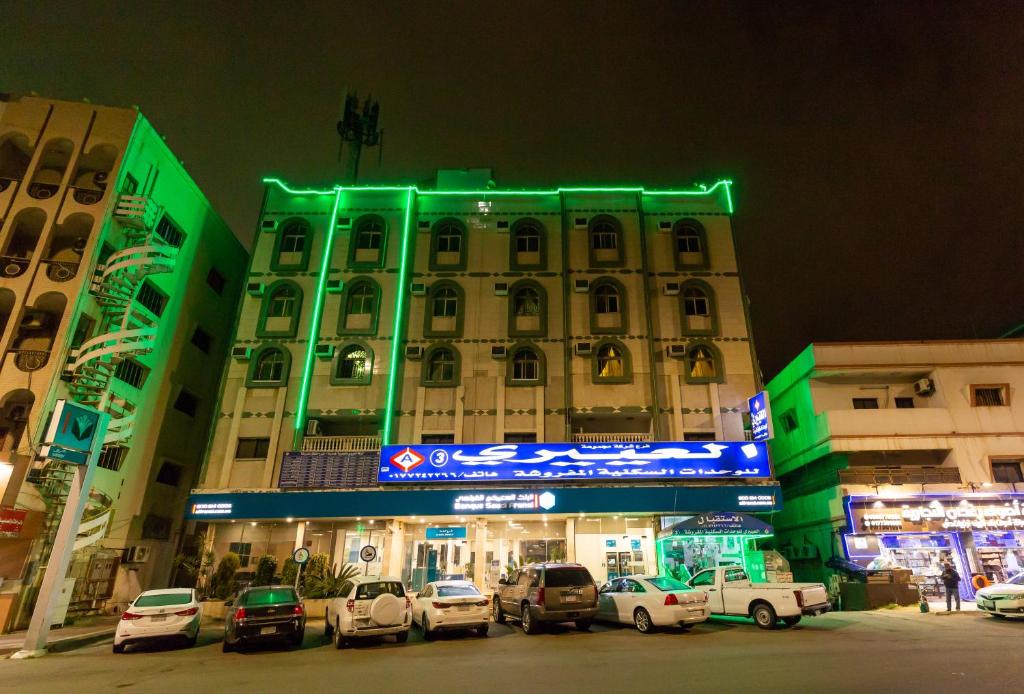 een gebouw waar 's nachts auto's voor geparkeerd staan bij العييري للوحدات المفروشة الباحة3 in Al Baha