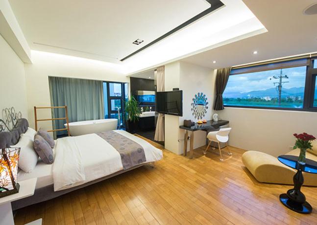 a bedroom with a bed and a desk and a television at Han-Shian Boutique B&amp;B in Dongshan
