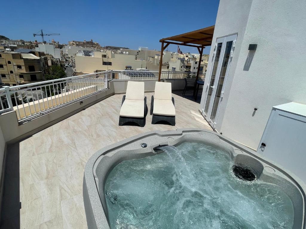 a hot tub on the balcony of a building at The Willows Penthouses with Jacuzzi in Għajn il-Kbira