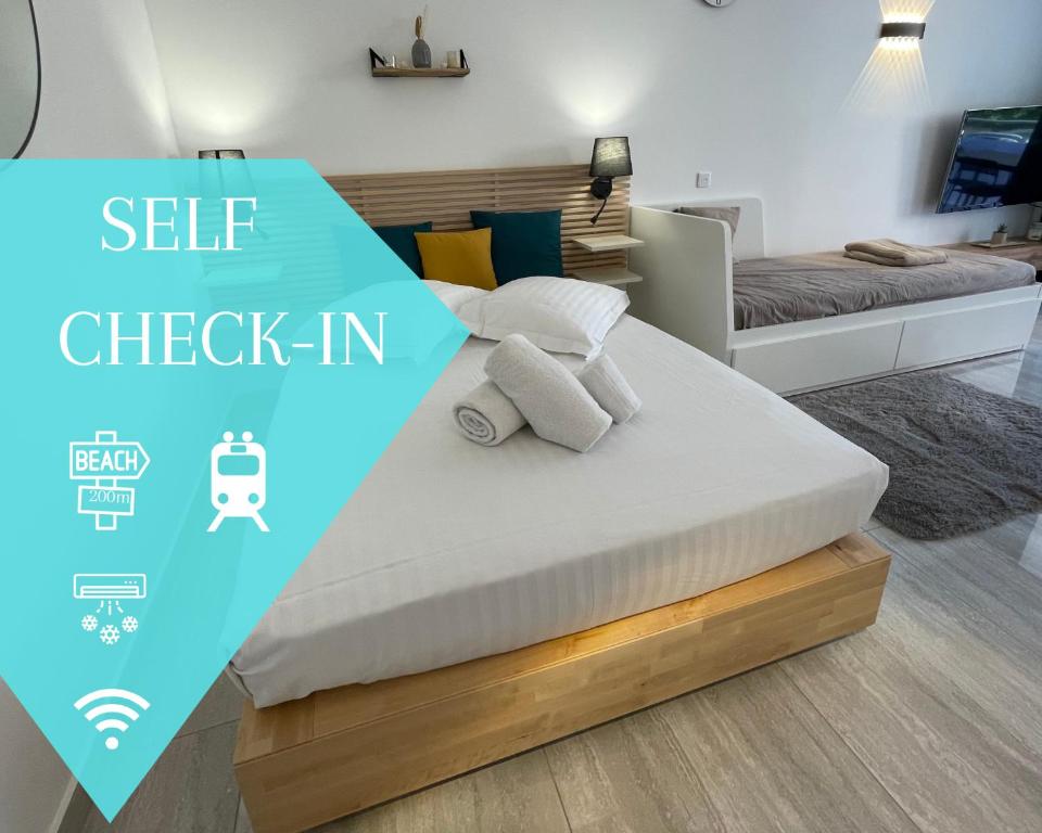 a bed in a bedroom with a blue sign that says self check in at Chaleureux studio, 200m de la plage, parking, wifi in Roquebrune-Cap-Martin