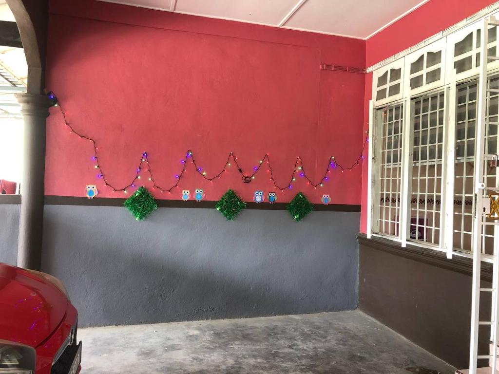 a red wall with christmas decorations on it at SERI LAZUARDI 6 (MUSLIM FRIENDLY) in Tanah Merah