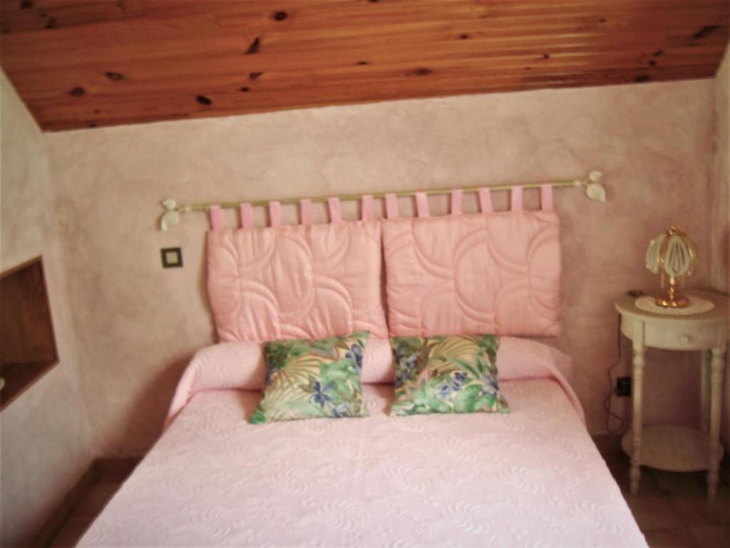Dormitorio con cama rosa y cabecero rosa en petite maison de montagne avec jardin, en Cier-de-Luchon