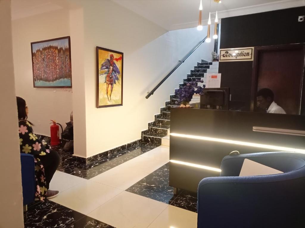 a group of people sitting in a lobby with stairs at NIAS Events & Suites in Abuja