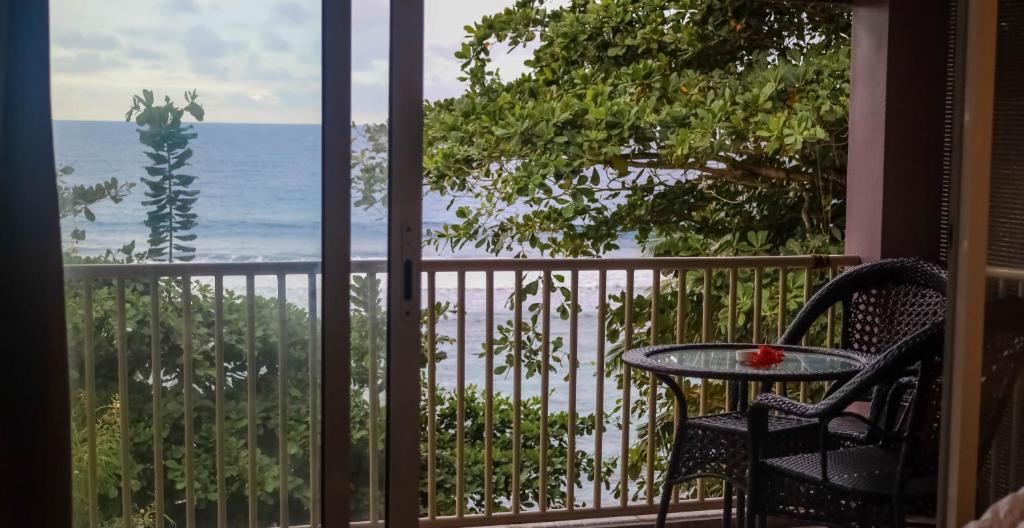 a balcony with a table and chairs and a view of the ocean at Will's Sea View Apartments in Victoria