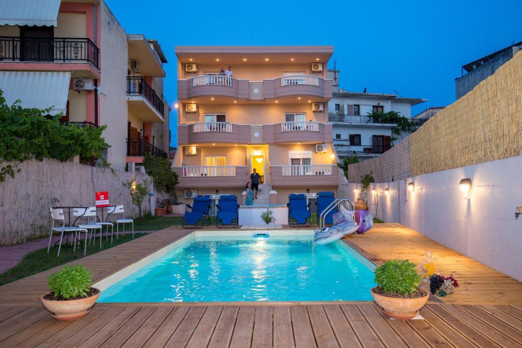 a swimming pool in front of a building at Alexa's Sunny Days in Limenaria