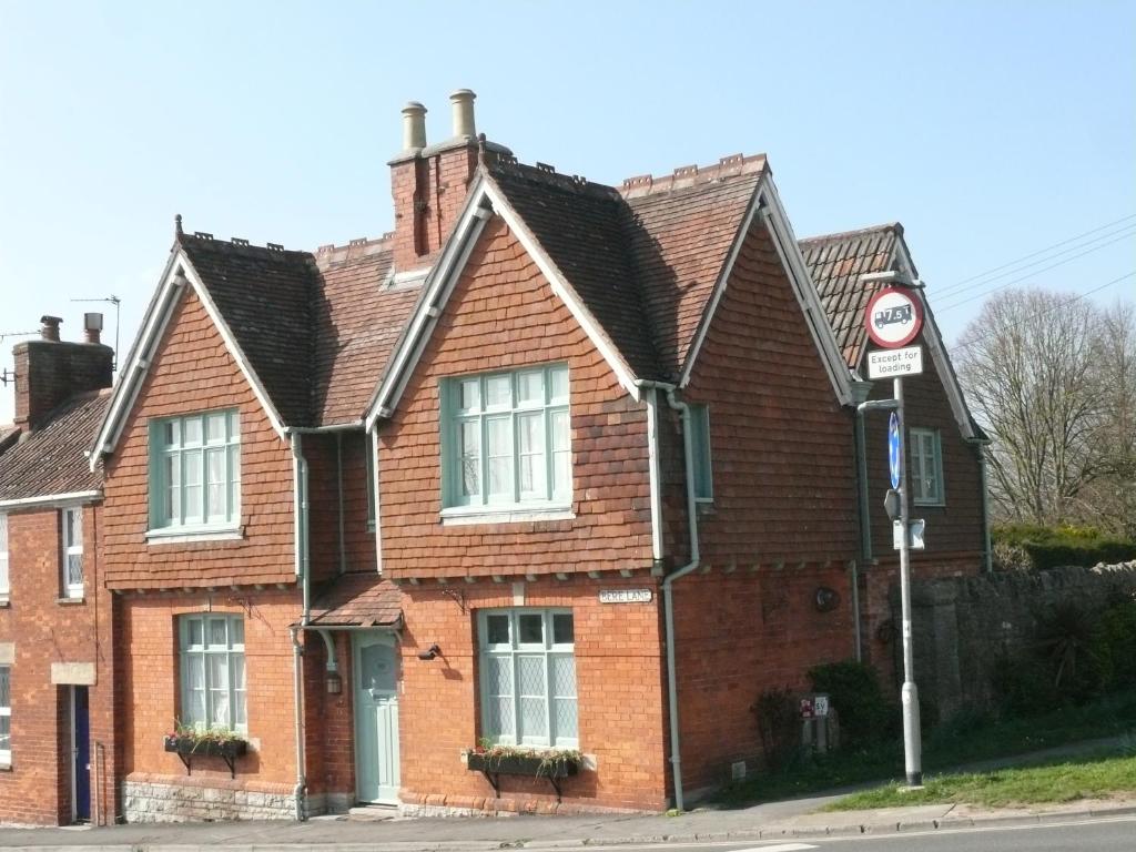 una casa de ladrillo marrón con techo negro en Parsnips House BnB Glastonbury en Glastonbury