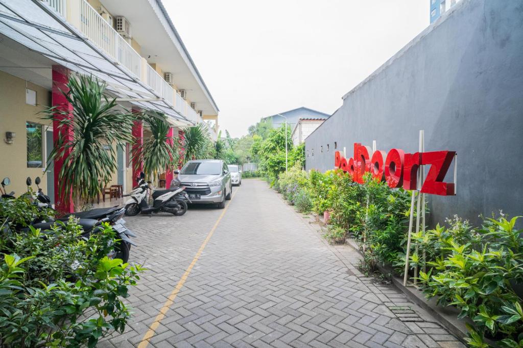 a street with cars parked on the side of a building at RedDoorz Syariah near Suncity Mall Sidoarjo in Sidoarjo