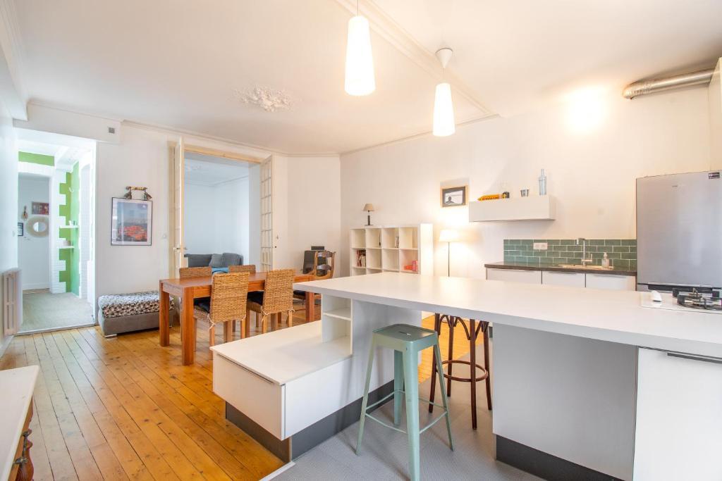 una cucina e una sala da pranzo con tavolo e sedie di Superbe Appartement Calme 85m², à deux pas du Centre a Nantes