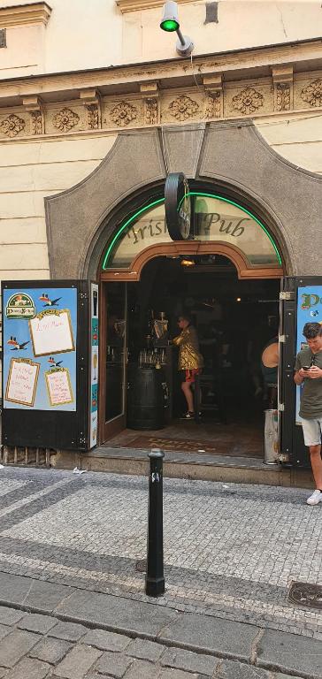 Eine Frau, die vor einem Laden steht. in der Unterkunft Durty Nelly's Pub in Prag