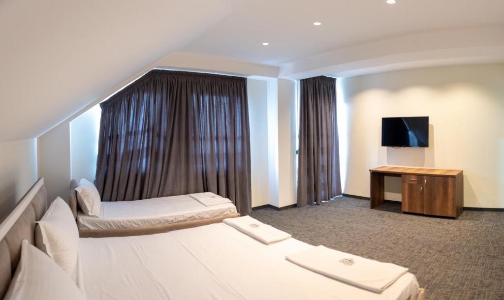 a hotel room with two beds and a television at Hotel Roma in Struga