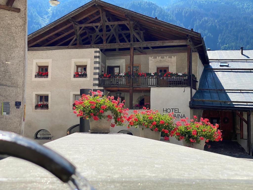 um edifício com flores em frente a um edifício em Hotel Chasa Chalavaina em Müstair