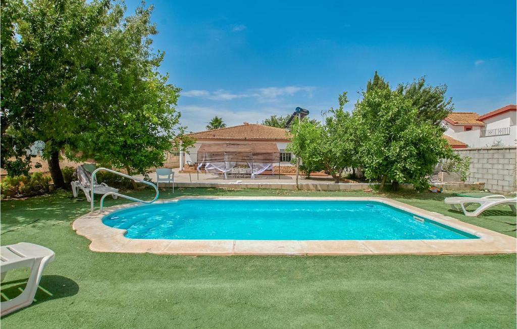 - une piscine dans une cour avec des chaises et des arbres dans l'établissement Nice Home In La Carlota With Kitchenette, à La Carlota