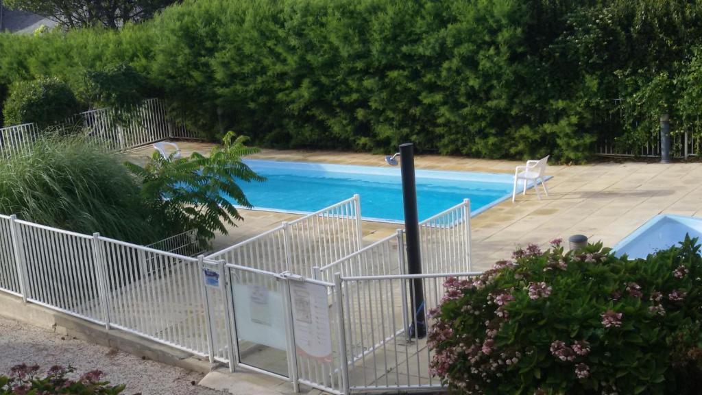 a swimming pool with a white fence next to it at Ty Avel Studios 110 et 111 in Quiberon