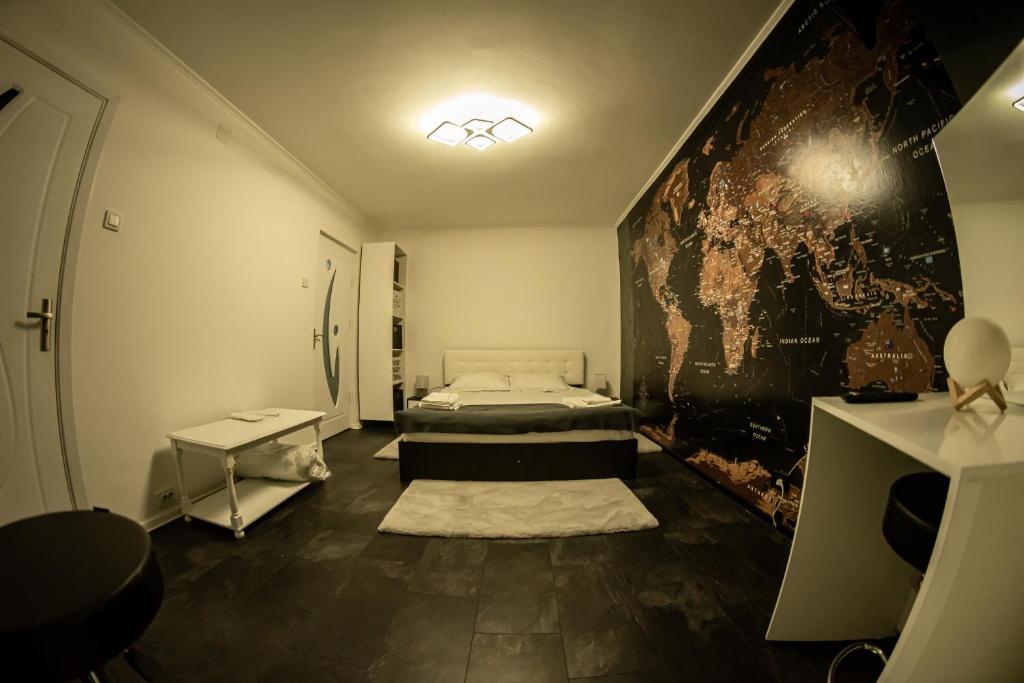 Habitación con cama y mapa en la pared en Studio Six Continents, en Petroşani