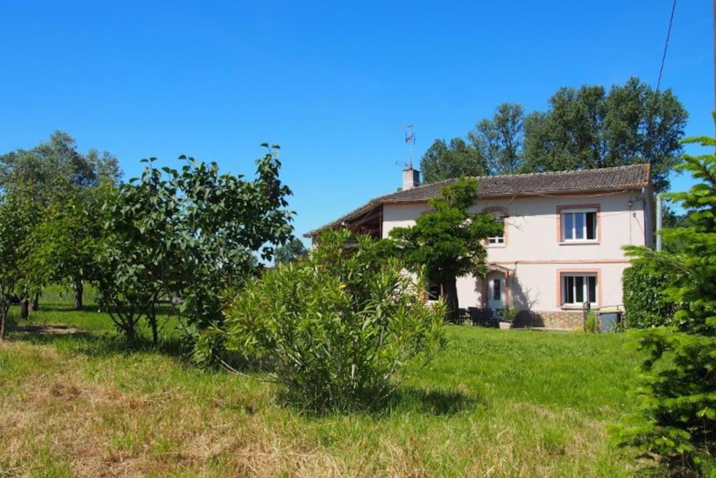 uma casa no meio de um campo com árvores em La Case à Jane, gite familial en pays tarnais em Coufouleux