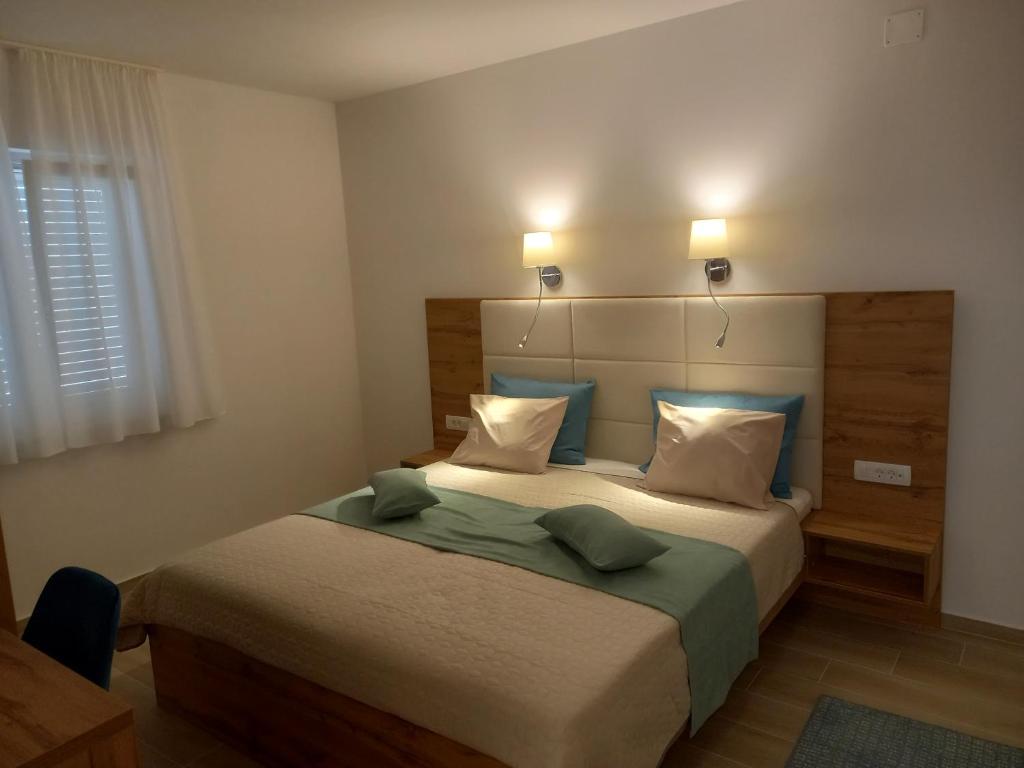 a bedroom with a large bed with two pillows at Arba sunshine in Rab