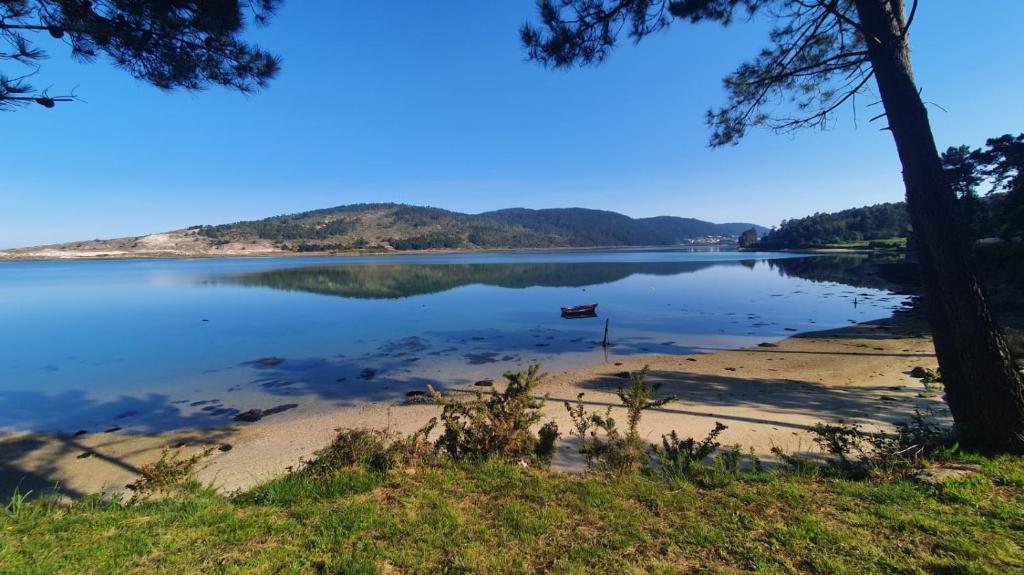 a view of a lake with a boat on the shore at apartamento costa da morte cabana de bergantiños in A Coruña