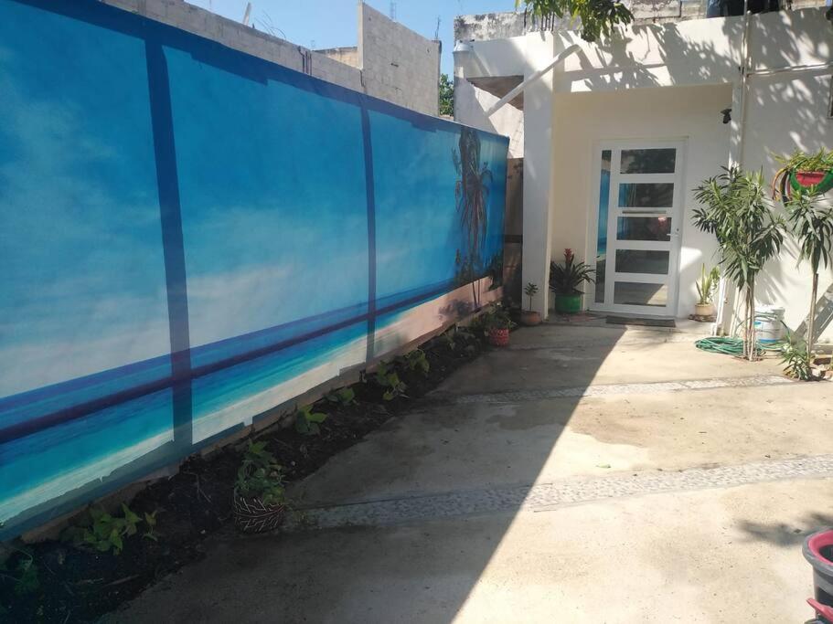 una cerca azul junto a una casa con una puerta en Casa bonita a dos cuadras del mar en Playa del Carmen
