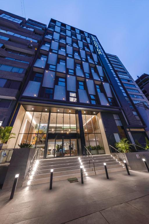 un edificio alto con luces delante en Casa Andina Standard Benavides, en Lima