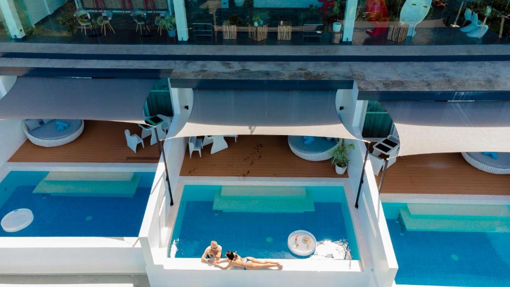 an aerial view of a pool with two people in the water at Epic Suites Bohol ADULTS ONLY in Dauis