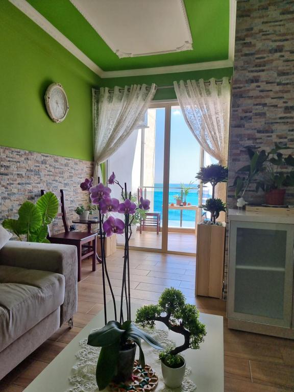 a living room with a couch and a table with flowers at Seaview Luxury Apartment in Durrës