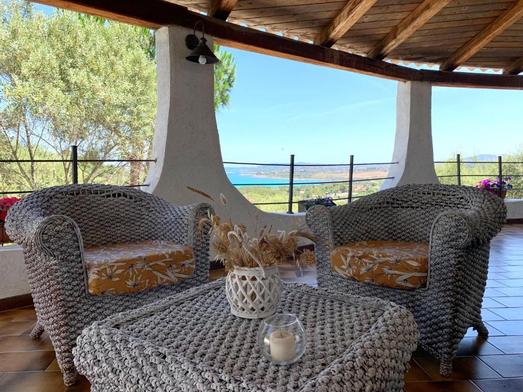 two wicker chairs and a table on a porch at Casa Le Cicale in Porto Istana
