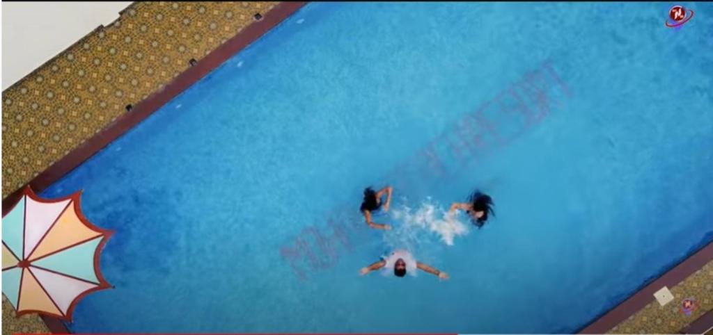 two people are swimming in a swimming pool at Mohana Beach Resorts Mandarmani in Mandarmoni