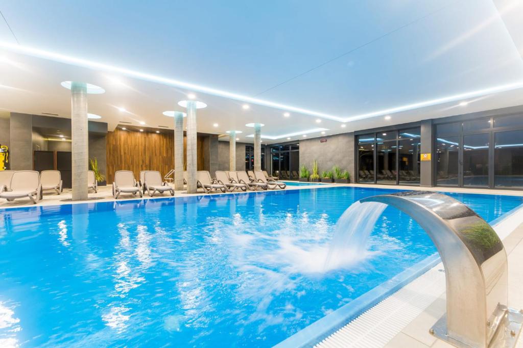 een zwembad met een fontein in een hotel bij Luksusowy Apartament Polanki Park z krytym basenem in Kołobrzeg