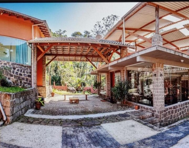 een patio van een huis met een houten pergola bij Solar corcovado in Ubatuba