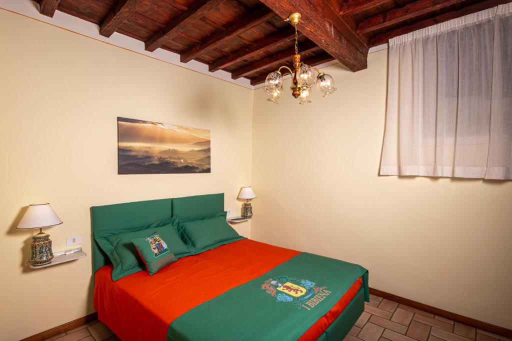 IBibiena - CASA NATALE BERNARDO TANUCCI في ستيا: غرفة نوم مع سرير ملون في غرفة