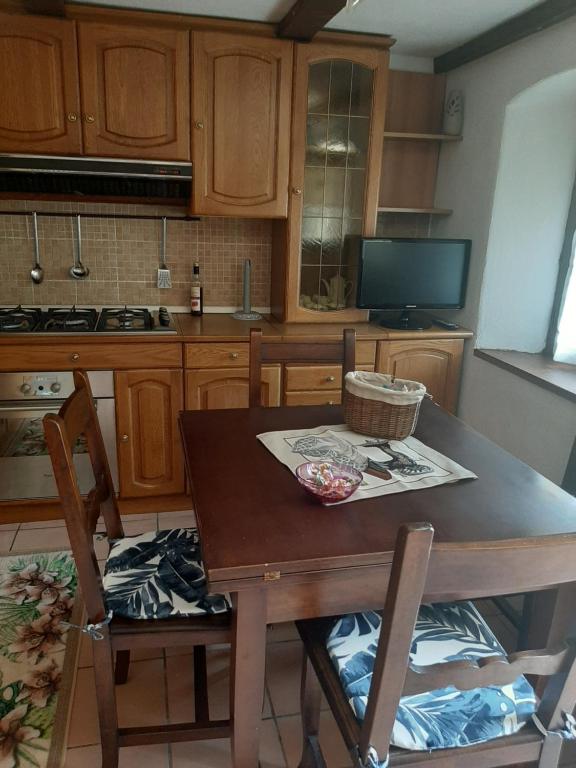 - une cuisine avec des placards en bois, une table et des chaises dans l'établissement Casa Elena, à Nus